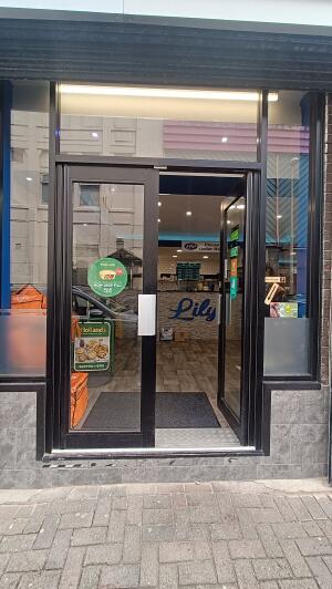 Black metal-framed glass doors to venue. Push from handle at centre to open.