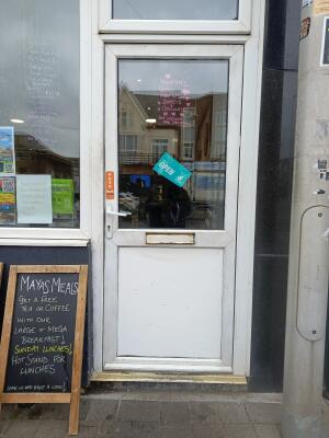 White metal-framed glass door. Push from handle on left to open.