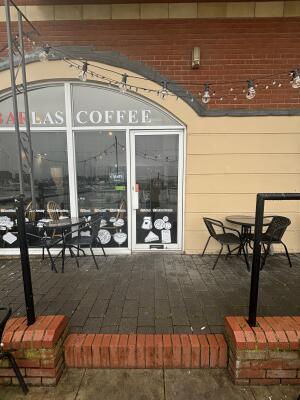 From sidewalk facing venue. Opening ahead to venue entrance at back. Black metal handles on left and right of opening.