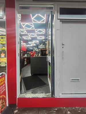 White metal-framed glass door. Push from handle on left to open.