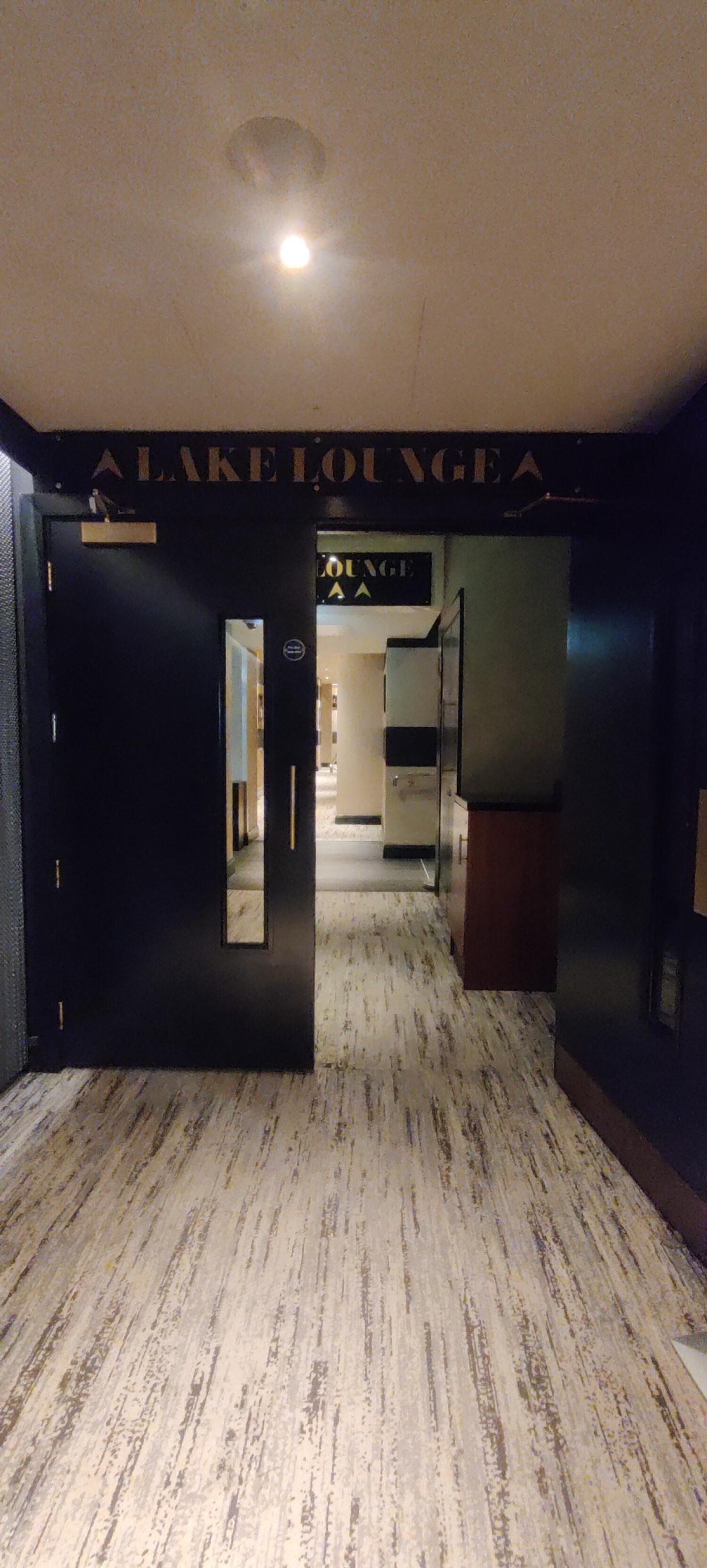 From door facing left. Second set of black wooden doors with glass panel in centre, ahead. Pull from handle in center to open.