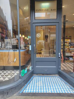 Dark grey wood-framed glass door. Push from handle on left to open.