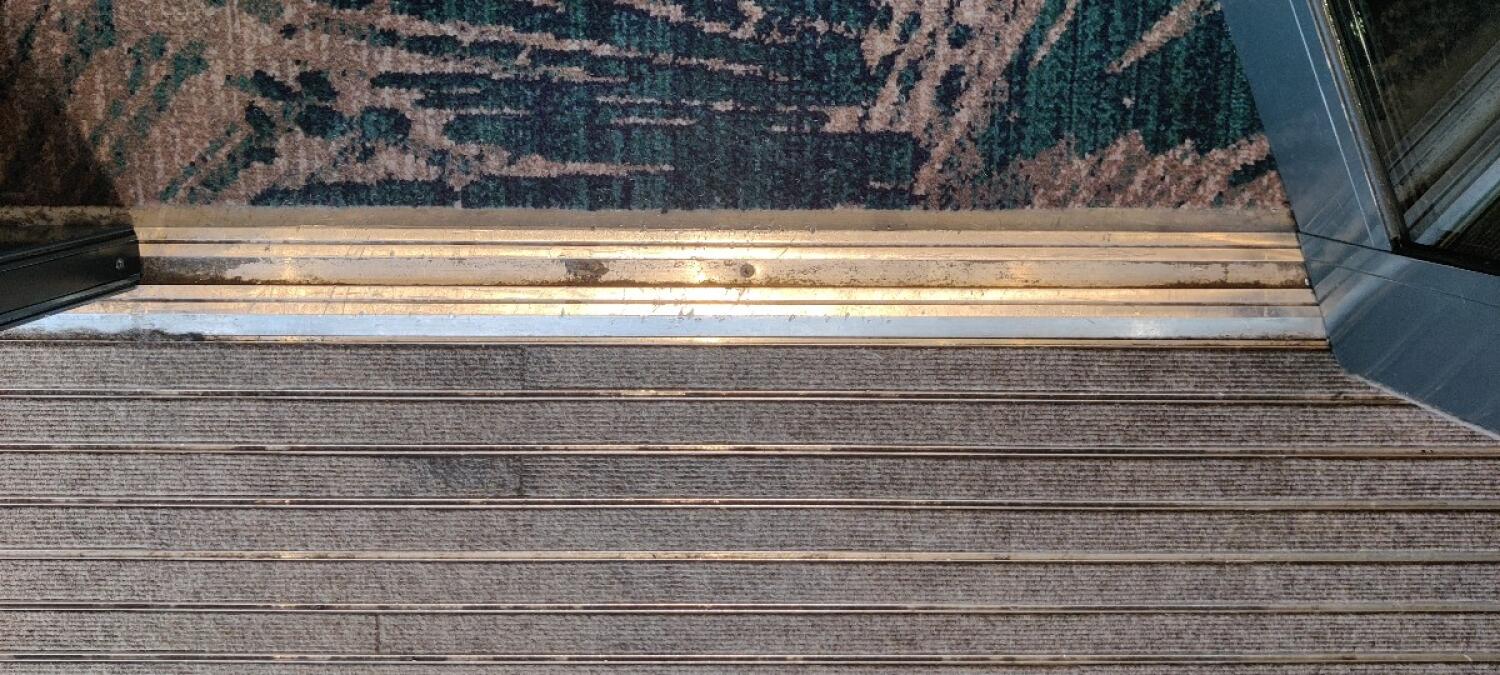 Small bump at foot of door. Floor with carpet beyond.