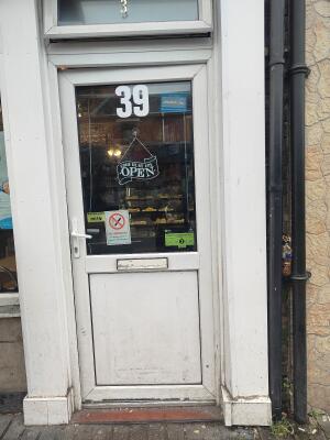 White metal-framed glass door. Push from handle on left to open.