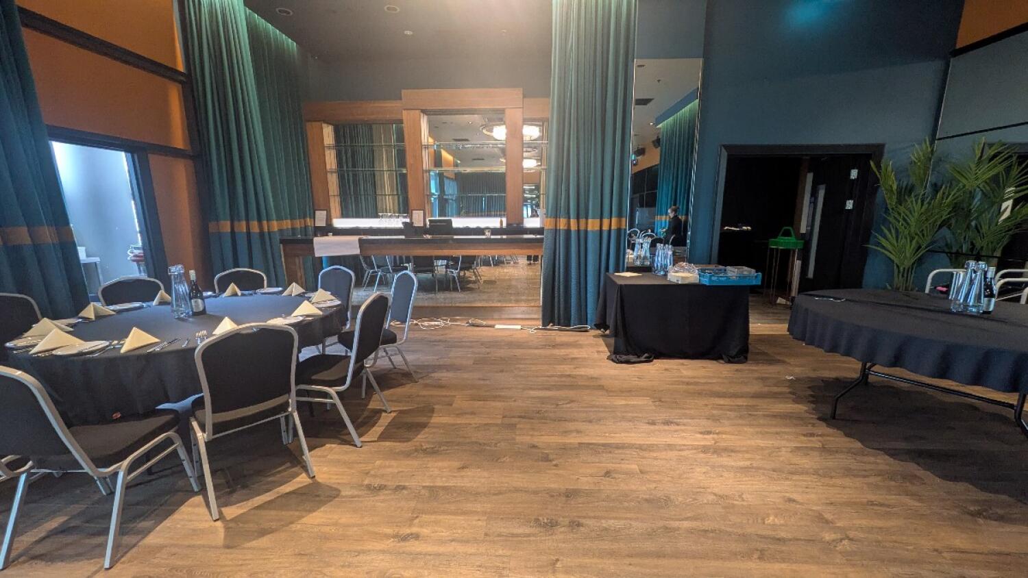 From end of path facing straight. Table on left. Bar counter with chairs at back. Tables with drinks and glasses on right.