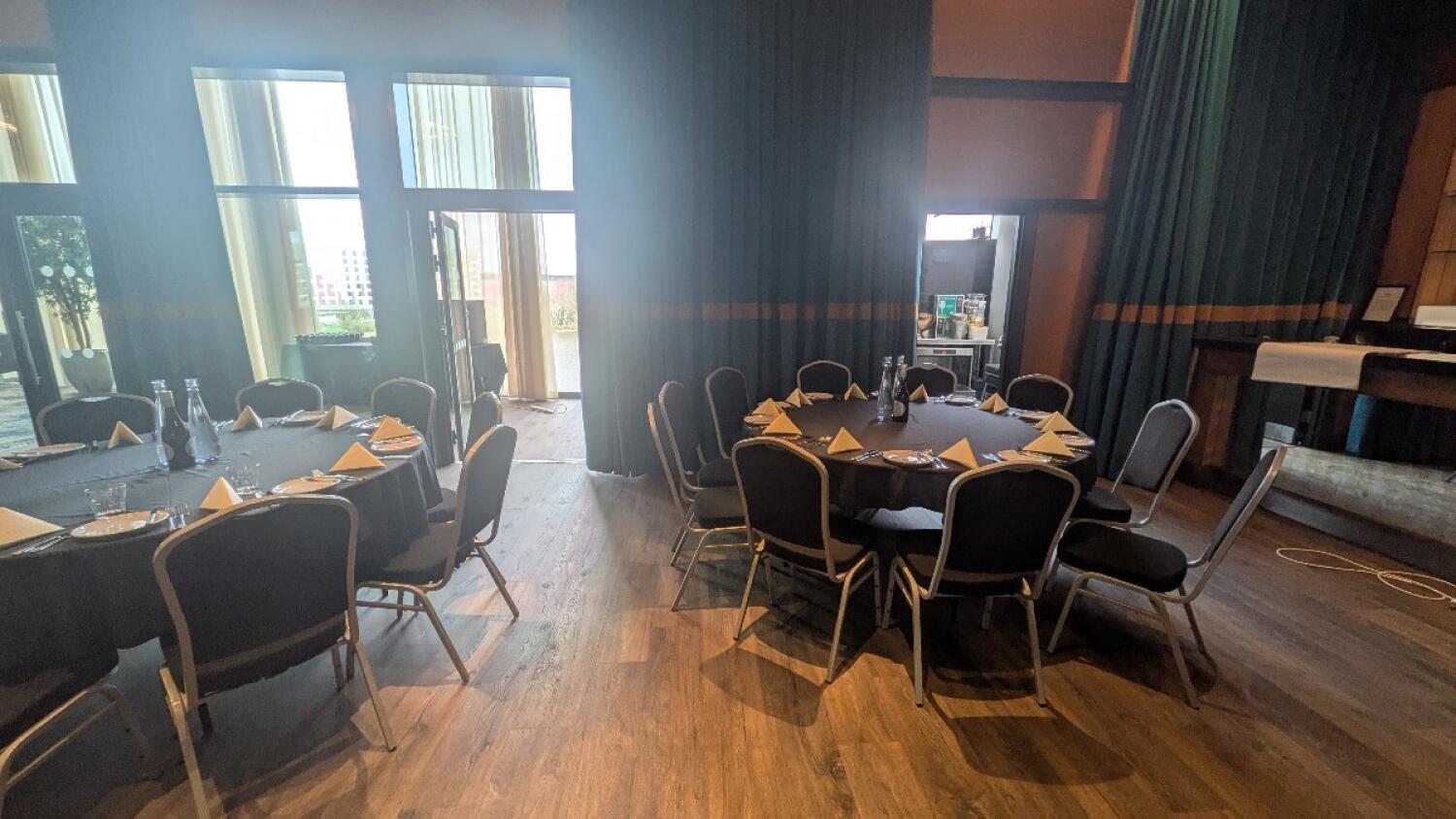From end of path facing left. Tables with chairs along left and centre. Door to back area at back.