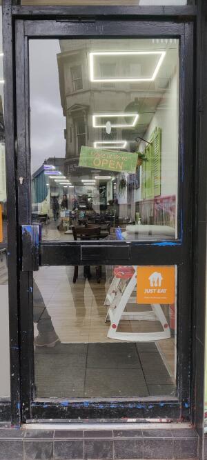 Black metal-framed glass door. Pull from handle on left to open.