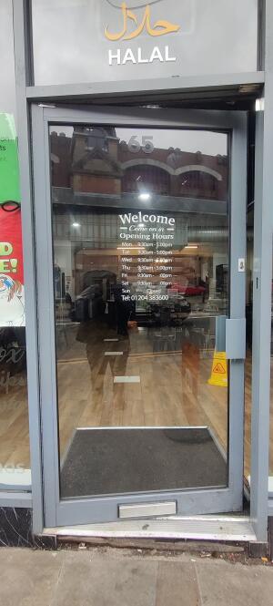 Grey metal-framed glass door ahead. Push from handle on right to open.