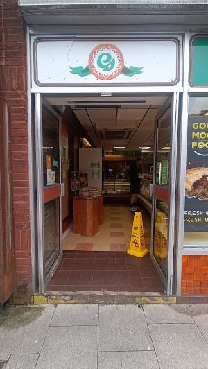 Glass doors with metal frames to venue. Push from handles at centre to open.