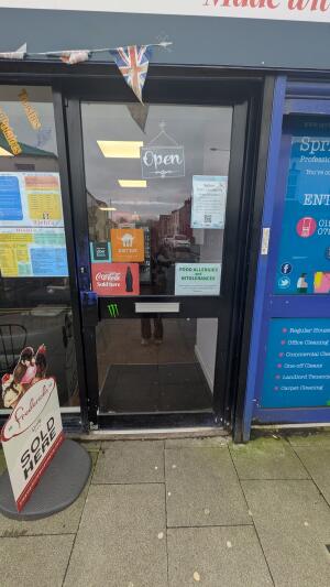 Black metal-framed glass door. Push from handle on right to open.