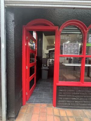 Red wood-framed glass door. Pull from handle on right to open.
