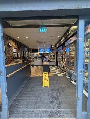 Blue metal-framed glass sliding doors. Doors slide open automatically to each side.