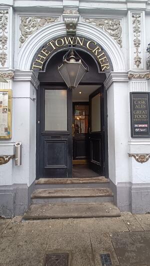Black glass-panelled wooden door to venue. Push from handle in centre to open.