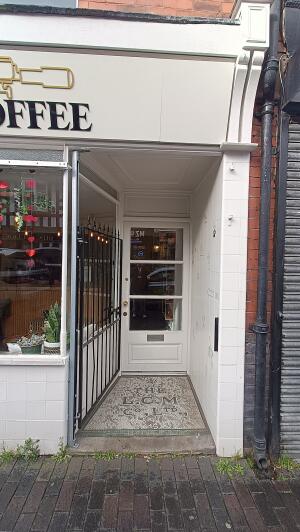 Black panelled metal door to venue. Push from handle on right to open.