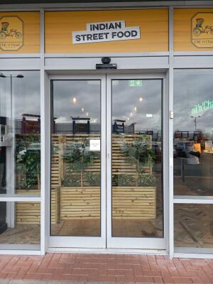 Silver metal-framed glass doors ahead. Automatic doors slide to left and right open.