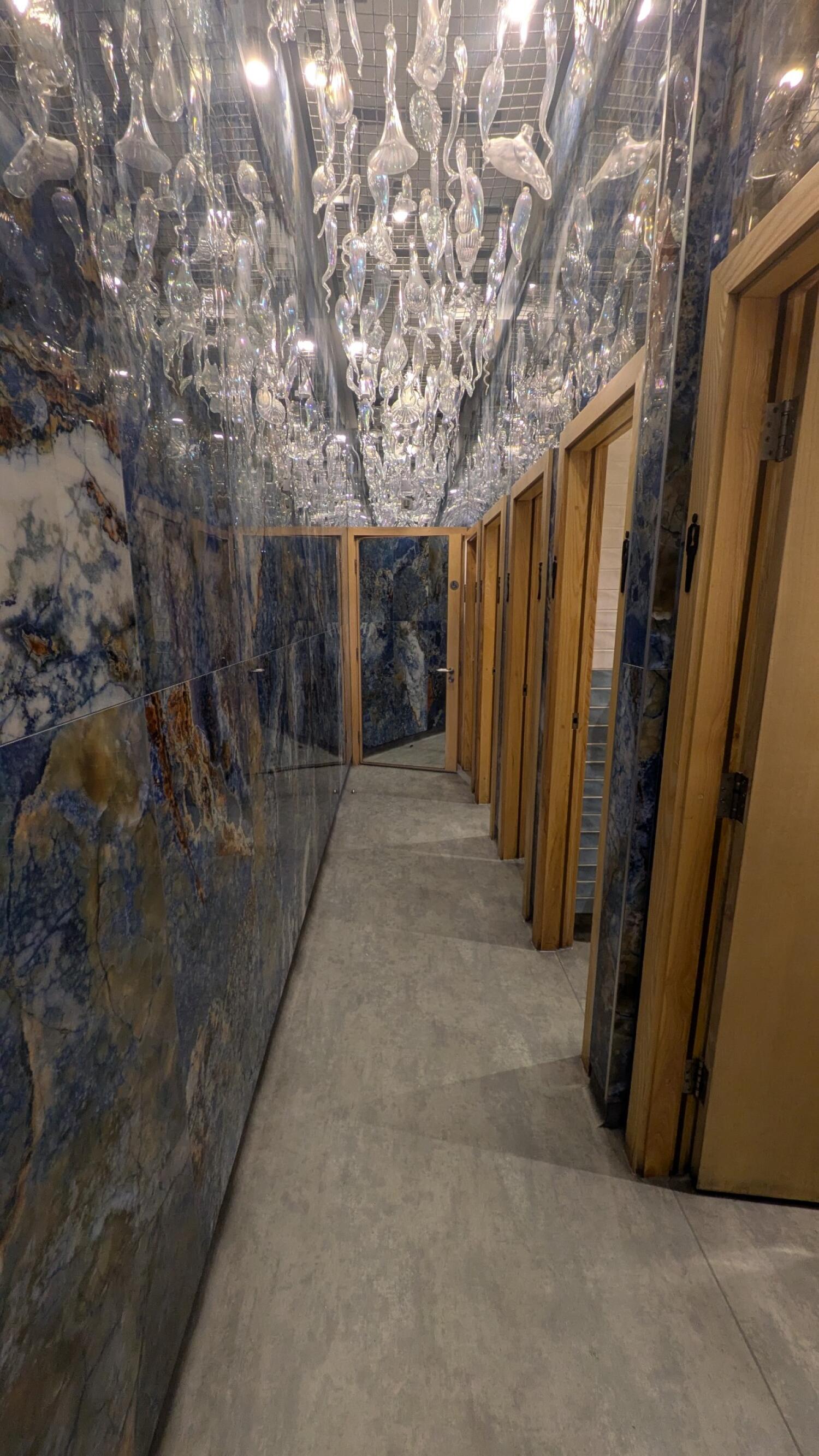From door facing straight. Pathway with doors on right leading to door at end.