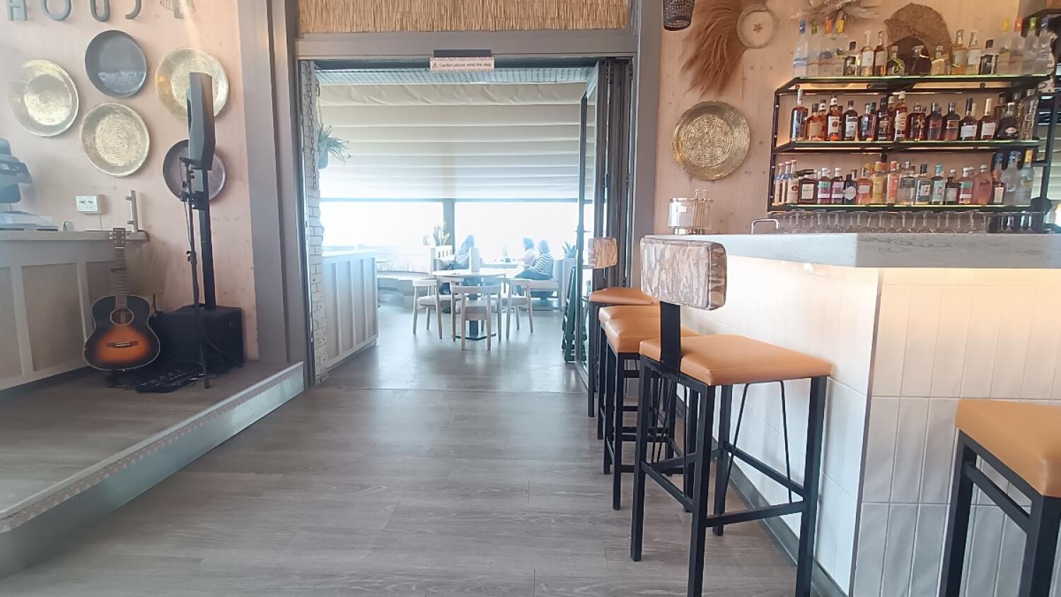 From end of high table facing right. Path to back seating in centre. Bar counter with stools along right.