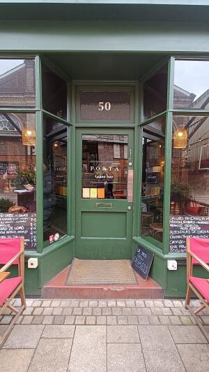 Green wooden-framed glass door to venue. Push metal plate on left to open.