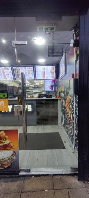 Glass door with metal handle. Push from handle on left to open.