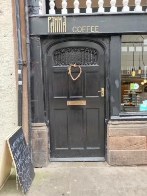 Black wooden door ahead. Push from handle on right to open.