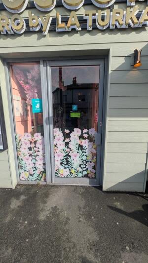 Grey metal-framed glass doors with floral design. Pull from handle on right to open.