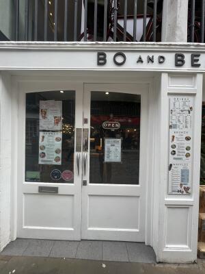 White wood-framed glass doors. Pull from metal handles at centre to open.