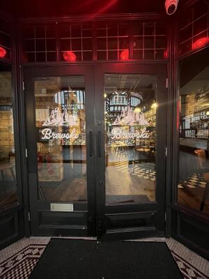 Black metal-framed glass doors. Pull from handles at centre to open.