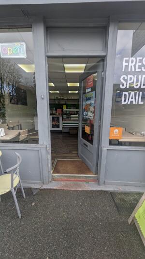 Grey wooden-framed glass door. Push from handle on left to open.
