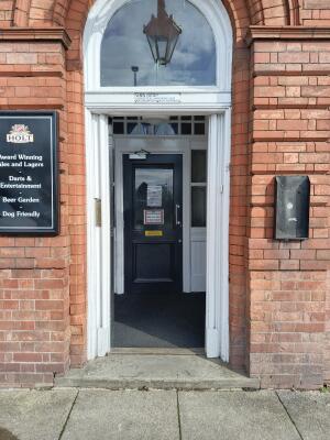 Dark grey wooden door ahead. Push from handle on right to open.
