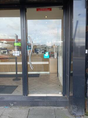 Black metal-framed glass door. Push from handle on left to open.