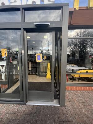 Dark grey metal-framed glass door. Door slides left to open.