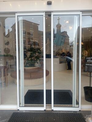 White metal-framed glass doors ahead. Doors automatically slide to left and right to open.