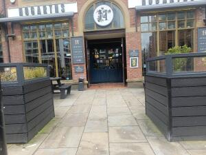 From street facing venue. Planters on left and right. Path at centre.