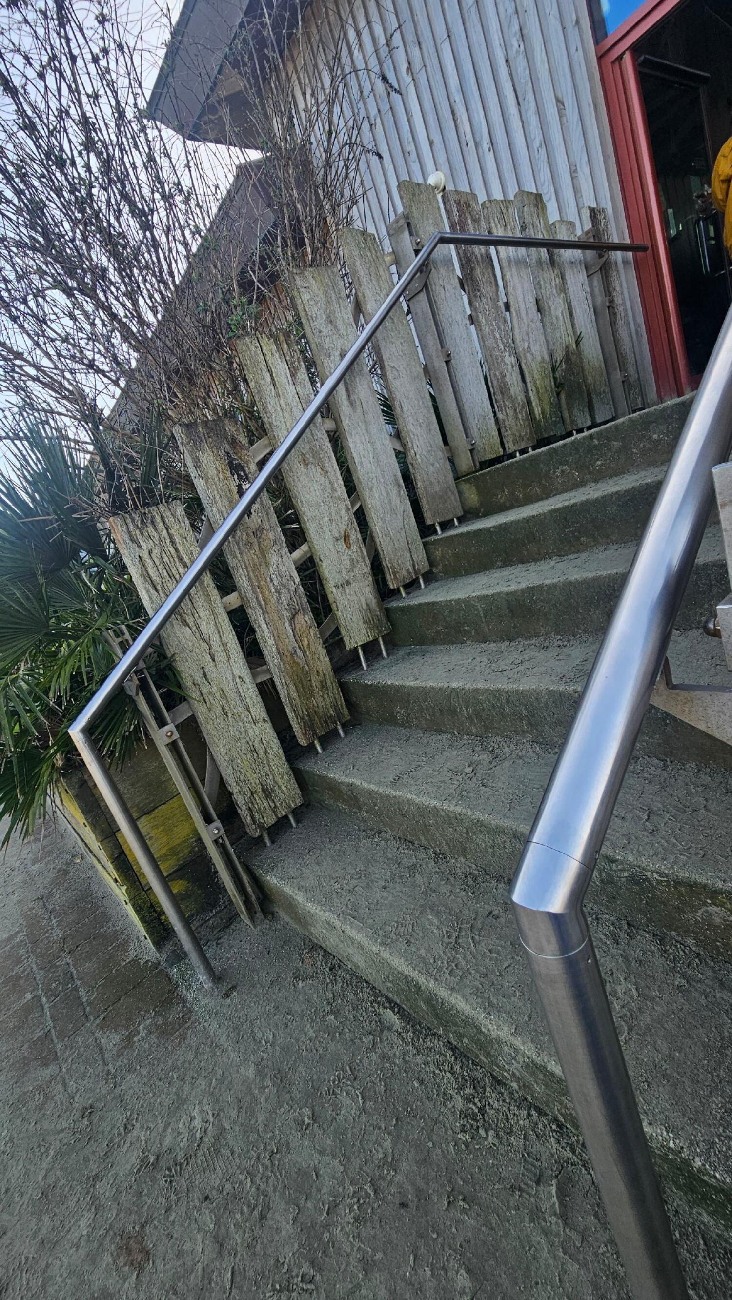 Staircase ahead, leading up. Handrails along left and right.