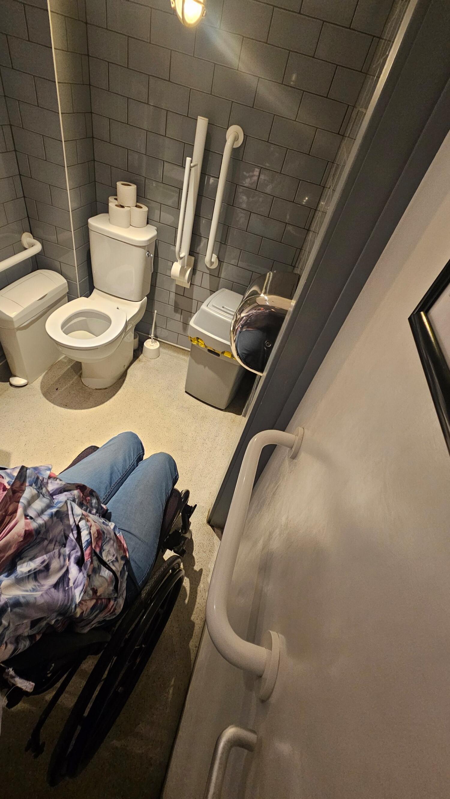 Toilet at back wall. Sink on right wall. Bin beneath sink.