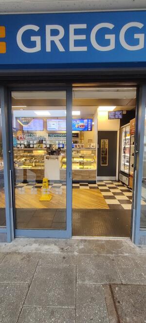 Blue metal-framed glass door ahead. Slide from handle on right to open.