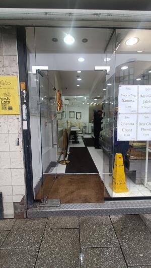 Glass doors with metal handles on right to venue. Push from handles to open.