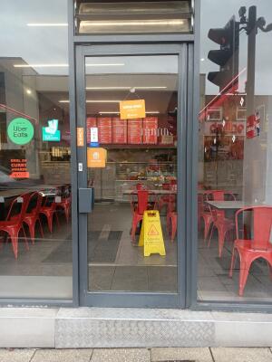 Grey metal-framed glass door ahead. Push from handle on left to open.