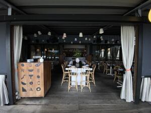 Open archway to venue. Welcome desk on left. Tables and chairs behind.