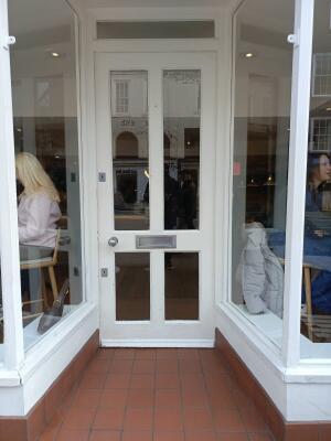 White wood-framed glass door ahead. Push from handle on left to open.