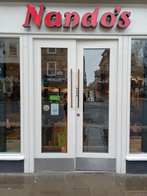 White wood-framed glass doors ahead. Push from metal handles at centre to open.