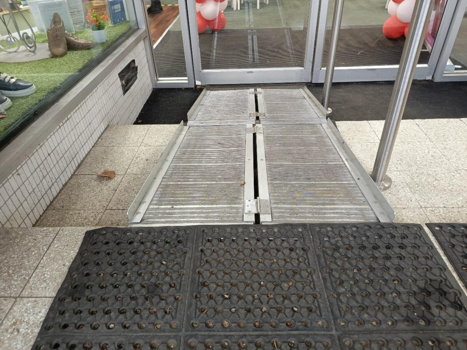 Slope at foot of door. Rubber mat before slope.