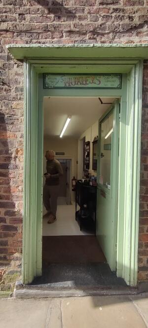 Light green wooden door ahead. Push handle on left to open.