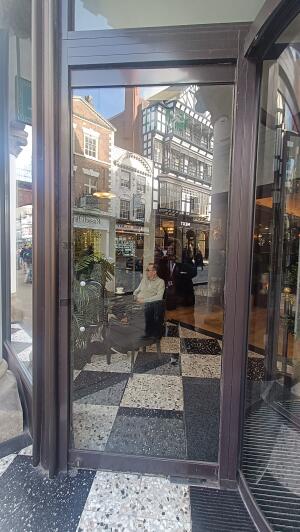 Brown metal-framed glass door to venue. Pull from handle on left to open.