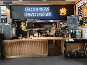 From street facing venue. Counter ahead with Fridge on left. Condiment station on right.