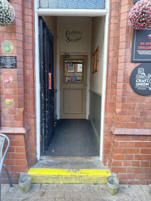 Black wooden door ahead. Push from right to open.