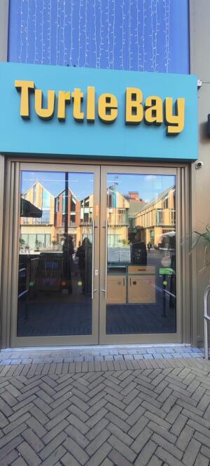 Grey metal-framed glass doors ahead. Pull from handles at centre to open.