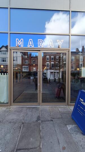 Bronze metal-framed glass doors to venue. Push from handles at centre to open.