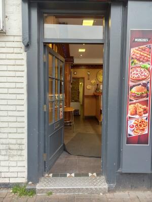Dark grey wood-panelled glass door ahead. Push from handle on left to open.
