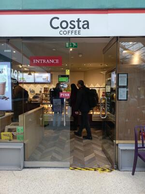 Glass doors with metal handles at centre. Push from handles at centre to open.